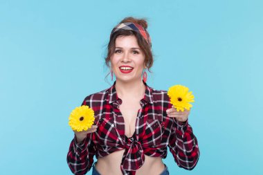 Yaz, pin-up ve eğlenceli kavram - mavi arka plan üzerinde gerberas ile güzel kadın