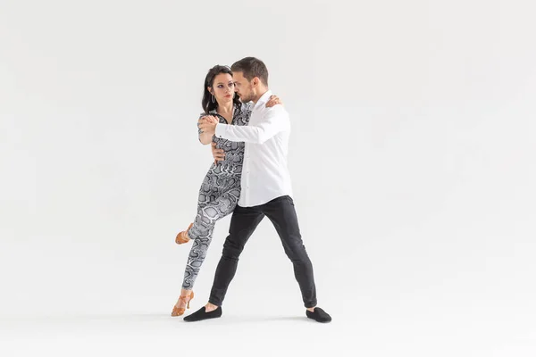 Casal jovem dançando bachata dança latina social, merengue, salsa. Dois pose elegância no fundo branco com copyspace — Fotografia de Stock