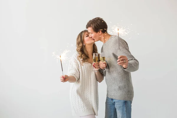 新年、休日、日付、バレンタインデーのコンセプト - 白い背景の上にスパークラーライトとシャンパンのグラスを保持する愛するカップル — ストック写真
