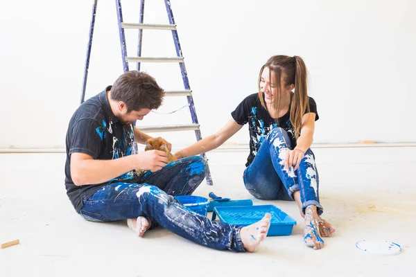 Réparation, animal, concept de famille et de rénovation - jeune couple avec chat va peindre les murs, en choisissant la couleur — Photo