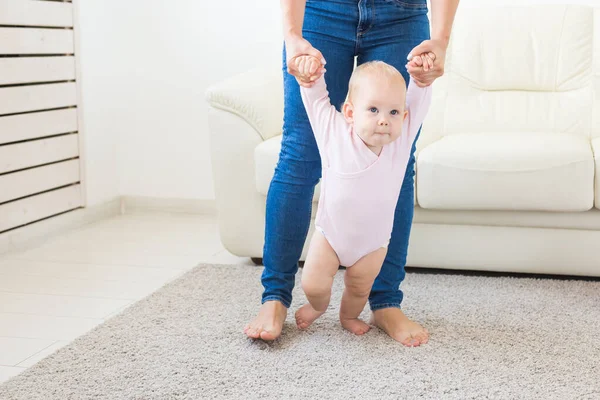 Baby het nemen van de eerste stappen met moeders helpen thuis — Stockfoto