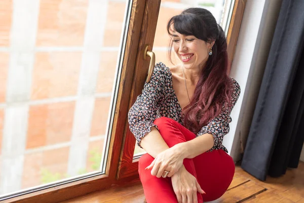 Mooie slanke vrouw zit bij het raam — Stockfoto