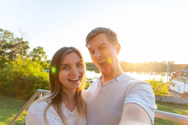 Bonito homem e jovem mulher se divertindo passar o tempo juntos e tomar selfie — Fotografia de Stock