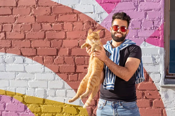 다채로운 벽 야외의 배경에 남자와 고양이 사이의 우정 — 스톡 사진