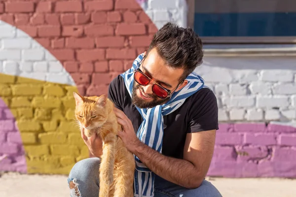 Conceito de amizade e animais de estimação - Bonito jovem com gato bonito ao ar livre — Fotografia de Stock