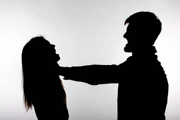 Domestic violence and abuse concept - Silhouette of a man asphyxiating a woman — Stock Photo, Image