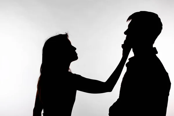 Aggression and abuse concept - man and woman expressing domestic violence in studio silhouette isolated on white background. — Stock Photo, Image