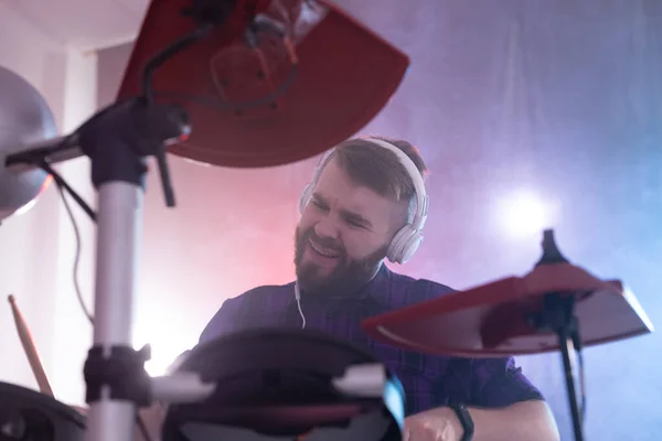Хобби, музыка и концепция людей - эмоциональный человек, играющий на барабанах — стоковое фото