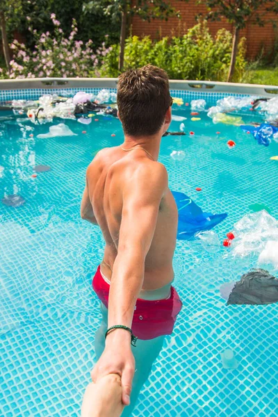 Ecologie, plastic afval, milieu nood en watervervuiling-Guy leiden in een zwembad met vuilnis — Stockfoto