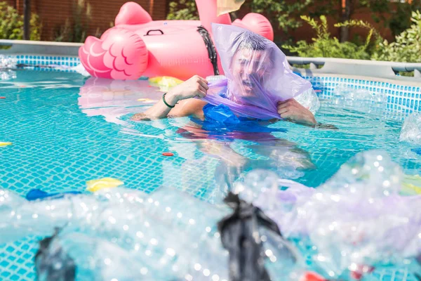 Ecologie, plastic prullenbak, milieu nood en watervervuiling-schreeuwen man met een plastic zak over zijn hoofd in een vuile zwembad — Stockfoto