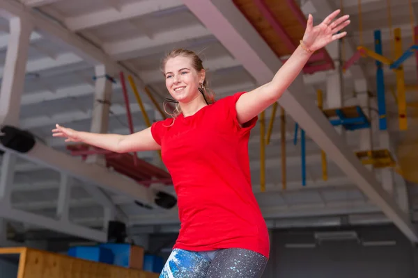 Fitness, diversión, ocio y deporte concepto de actividad - Mujer feliz joven saltando en un trampolín en el interior — Foto de Stock