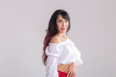 Latin dansı, striptiz dansı, çağdaş ve bachata bayan konsepti - doğaçlama dans eden ve uzun saçlarını beyaz arka planda gezdiren kadın