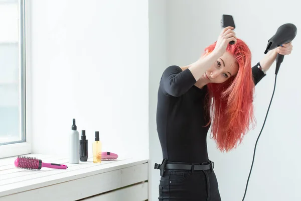 Stylist, fashion, hairdresser, people concept - woman drying her colored hair — Stock Photo, Image