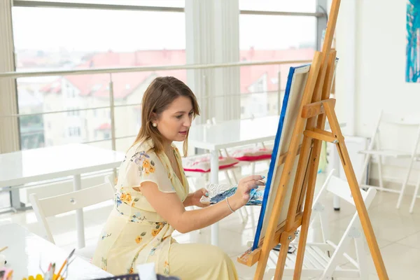 Aula de arte e conceito de desenho - Mulher artista trabalhando na pintura em estúdio . — Fotografia de Stock