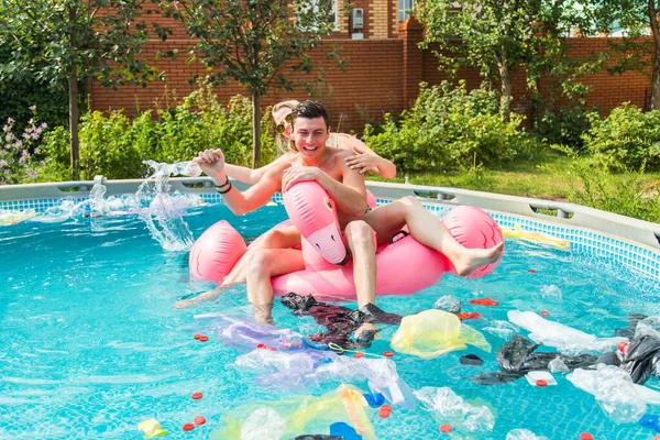 Jonge kerel en meisje plezier hebben terwijl het milieu vervuild is, concept van probleem plastic recycling en vuilnis afvoer — Stockfoto