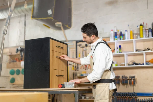 Meubelfabriek, kleine bedrijven en People concept-Young Man werkzaam bij de meubelproductie — Stockfoto