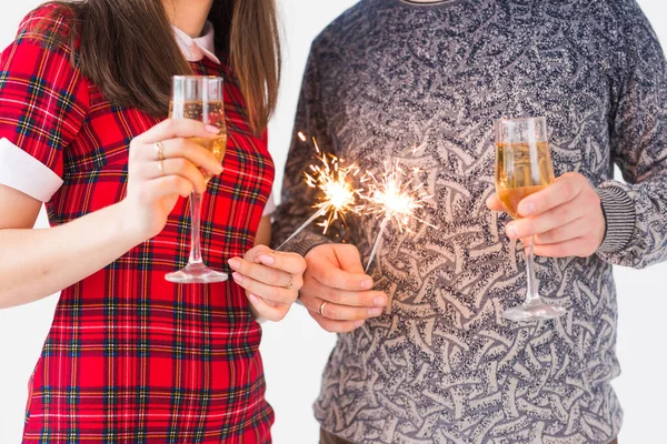 Primo piano di mani che tengono scintillanti e bicchieri di champagne. Fuochi d'artificio festeggiare di notte felice anno nuovo — Foto Stock