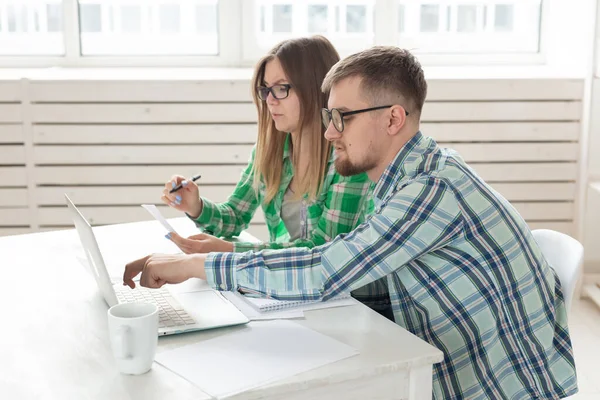 Mann und Frau diskutieren Betrag in Scheck für die Zahlung der Wohnung und vergleichen sie mit den Preisen auf der offiziellen Website, während sie am Tisch mit Laptop sitzen — Stockfoto