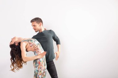 Genç çift dans sosyal Latin dans Bachata, Merengue, salsa. Kopya alanı ile beyaz arka planda iki zarafet poz
