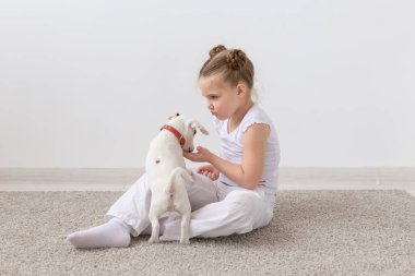 Evde beslenen hayvan, çocuk ve hayvan kavramı - katta oturan ve köpek yavrusu besleme çekici çocuk kız
