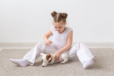 insanlar, çocuk ve pets kavramı - sevimli köpek Jack Russell Terrier ile yerde yatarken küçük çocuk kız