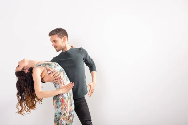 Casal jovem dançando bachata dança latina social, merengue, salsa. Dois pose elegância no fundo branco com espaço de cópia — Fotografia de Stock