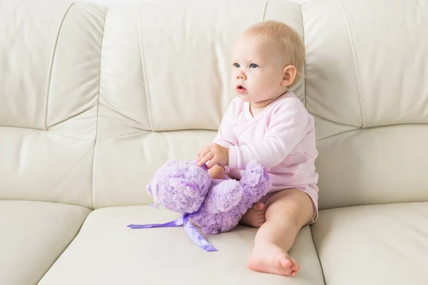 Los niños, el bebé y el concepto de la infancia - Hermoso bebé suave lindo sentado en el sofá — Foto de Stock