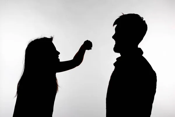Concepto de agresión y abuso - hombre y mujer expresando violencia doméstica en silueta de estudio aislados sobre fondo blanco . — Foto de Stock