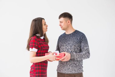 Kadın ve erkek hediye kutusunu tutuyorlar. Mutlu bir yeni yılı kutlarız.