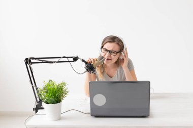Radyo, Dj, bloglama ve insan kavramı - Gülümseyen kadın mikrofon önünde oturan, radyo da ev sahibi