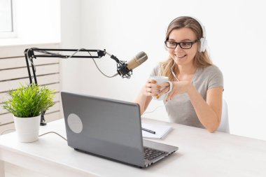 Radyo, Dj, bloglama ve insan kavramı - Gülümseyen kadın mikrofon önünde oturan, radyo da ev sahibi