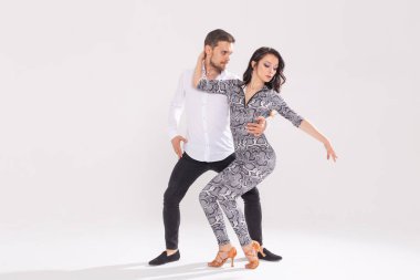 Dans eden genç çift Latin dansı bachata, merengue, salsa. Telif boşluğunda beyaz arkaplanda iki zarafet pozu