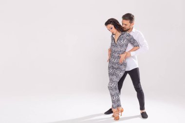 Genç çift dans latin dans bachata, merengue, salsa, kizomba. Kopyalama alanı ile beyaz arka plan üzerinde iki zerafet poz