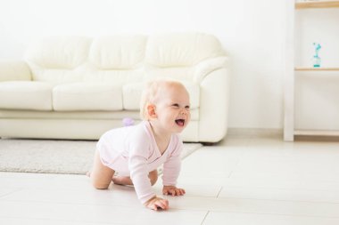 güzel gülümseyen bebek ilk kez sürünerek.