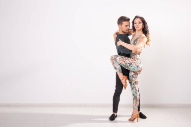 Genç çift dans latin dans bachata, merengue, salsa, kizomba. Kopyalama alanı ile beyaz arka plan üzerinde iki zerafet poz