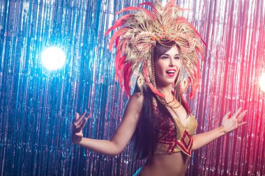 Karnaval, oryantal dans ve tatil konsepti - Altın kostüm giyen ve gülümseyen güzel kadın samba dansçısı