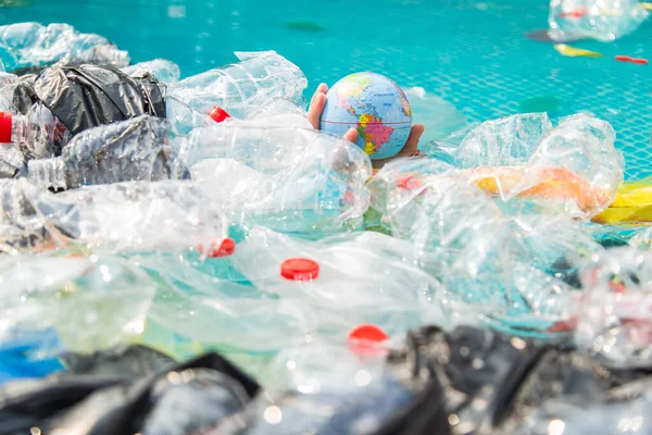 UFA, RÚSSIA - JULHO 25, 2019: Problema de lixo, reciclagem de plástico, poluição e conceito ambiental - Poluição de lixo plástico no ambiente da água, globo terrestre está flutuando no lixo — Fotografia de Stock