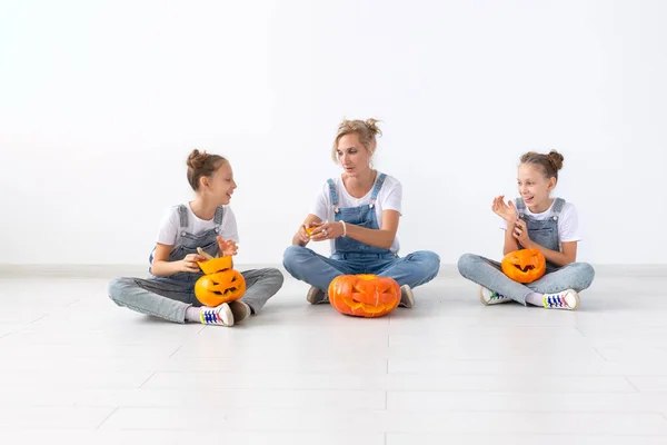 Happy Halloween en Holidays concept-een moeder en haar dochters met pompoenen. Happy Family bereidt zich voor op Halloween. — Stockfoto