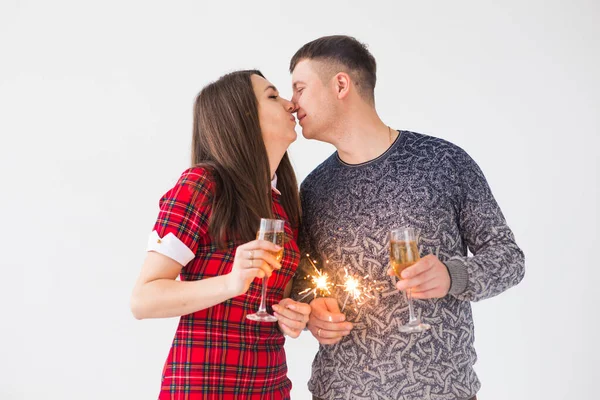 Coppia d'amore che tiene scintille e bicchieri di champagne. Fuochi d'artificio festeggiare di notte felice anno nuovo — Foto Stock