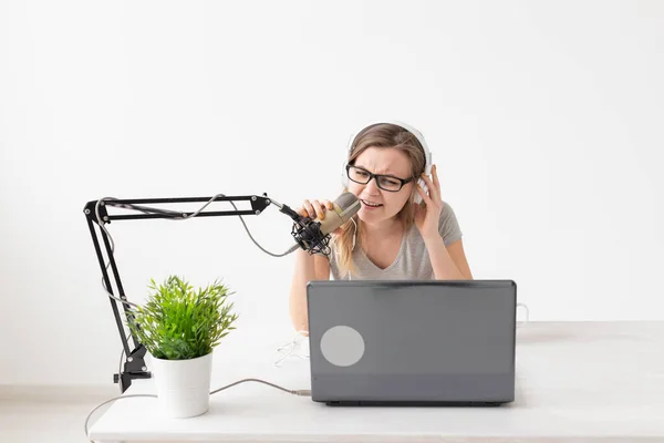 Radio, DJ, blogging y concepto de personas - Mujer sonriente sentada frente al micrófono, anfitriona en la radio — Foto de Stock