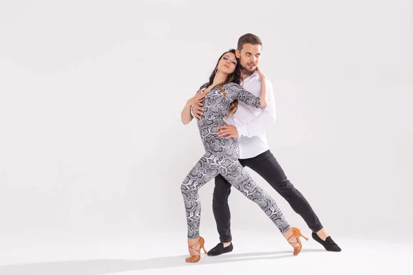 Dança social, bachata, kizomba, zouk, conceito de tango - Homem abraça mulher enquanto dança sobre fundo branco com espaço de cópia — Fotografia de Stock