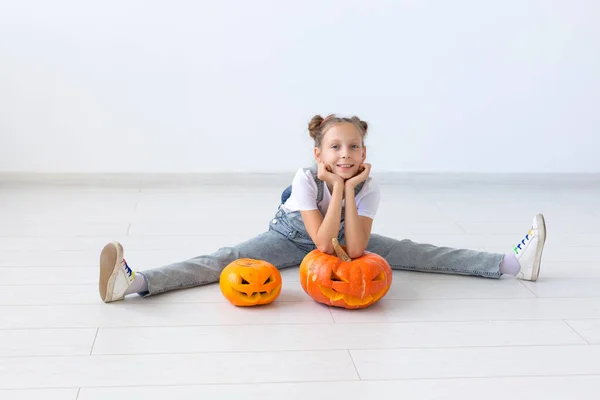 Buon Halloween, vacanze autunnali e concetto di infanzia - Carina bambina con una zucca Jack-o-lanterna al chiuso — Foto Stock
