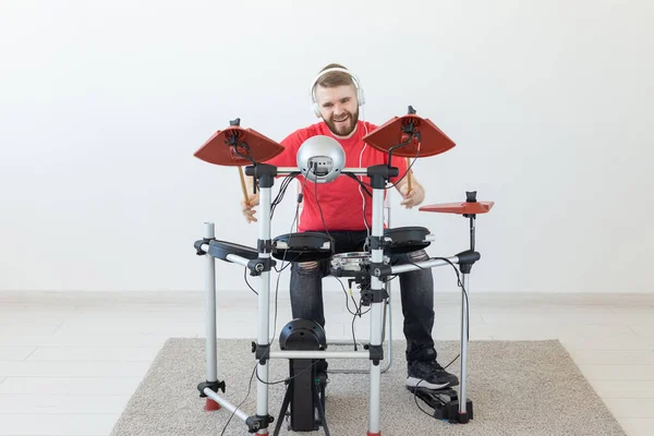 Mensen, muziek en hobby concept-man in zijn vrije tijd het spelen van de elektronische drumstel — Stockfoto