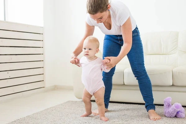 Little baby girl first steps with the help of mom — Stock Photo, Image