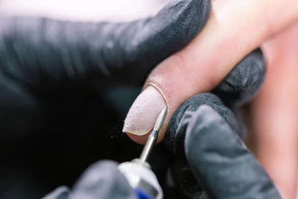 Manicurista utilizzare lima elettrica trapano nel salone di bellezza. Perfetta manicure unghie processo da vicino con scoppiare detriti volanti. — Foto Stock