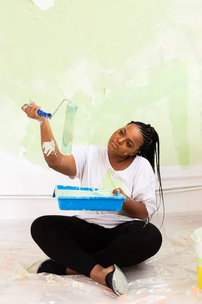 Apartman boyayan Afro-Amerikan kadın. Yenileme, onarım ve yeniden dekorasyon konsepti. — Stok fotoğraf