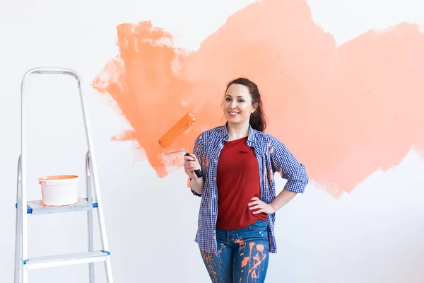 Lovely woman painting wall. Renovation, redecoration and repair concept. — Stock Photo, Image