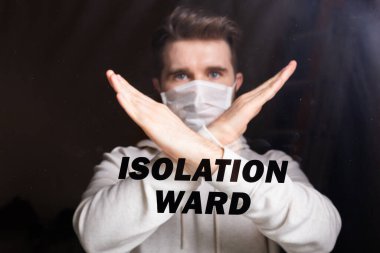 Solunum maskeli adam dur hareketi gösteriyor. Adam hayır işareti yapıyor. Coronavirüs veya covid-19 ve salgını durdurun. Evde kal. Karantina ve tecrit koğuşu kavramı.