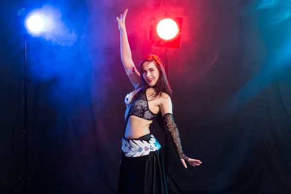 Young woman belly dancer in exotic dress with gold, dancing tribal fusion dance in studio. — Stock Photo, Image
