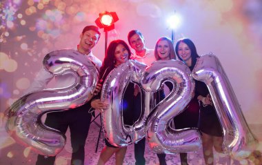 Parti, insanlar ve yeni yıl tatili konsepti - 2021 arifesinde kadınlar ve erkekler yeni yılı kutluyor.